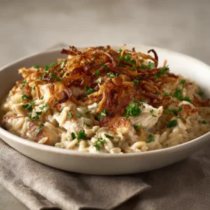 An extreme close-up of the creamy chicken orzo bake, showcasing the texture of the pasta and the rich, savory sauce.