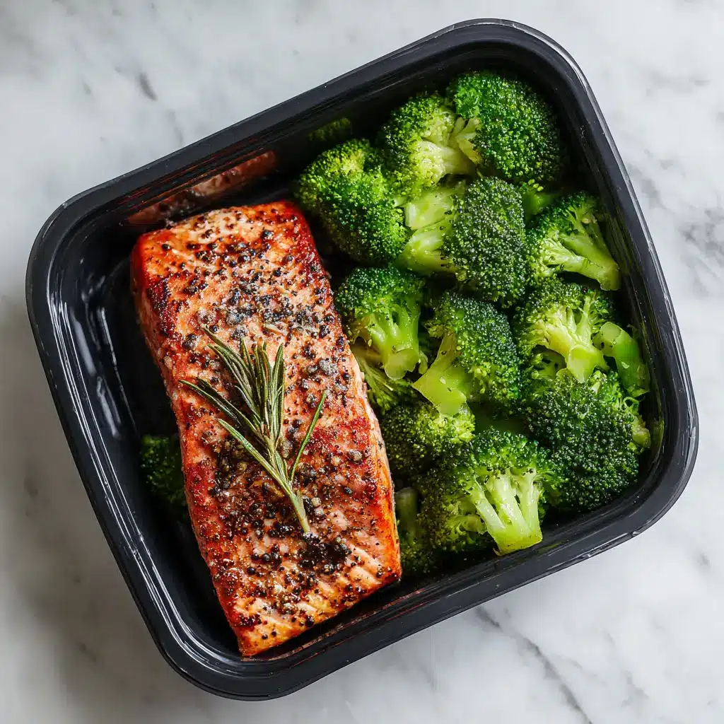 An arrangement of four salmon and broccoli meal prep containers, ready to be refrigerated for the week ahead. A showcase of easy meal planning.