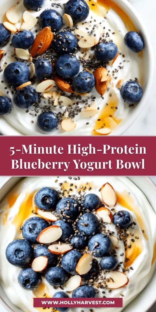 An overhead shot of a vibrant High Protein Blueberry Yogurt Bowl, topped with fresh blueberries, crunchy granola, and chia seeds in a white ceramic bowl.
