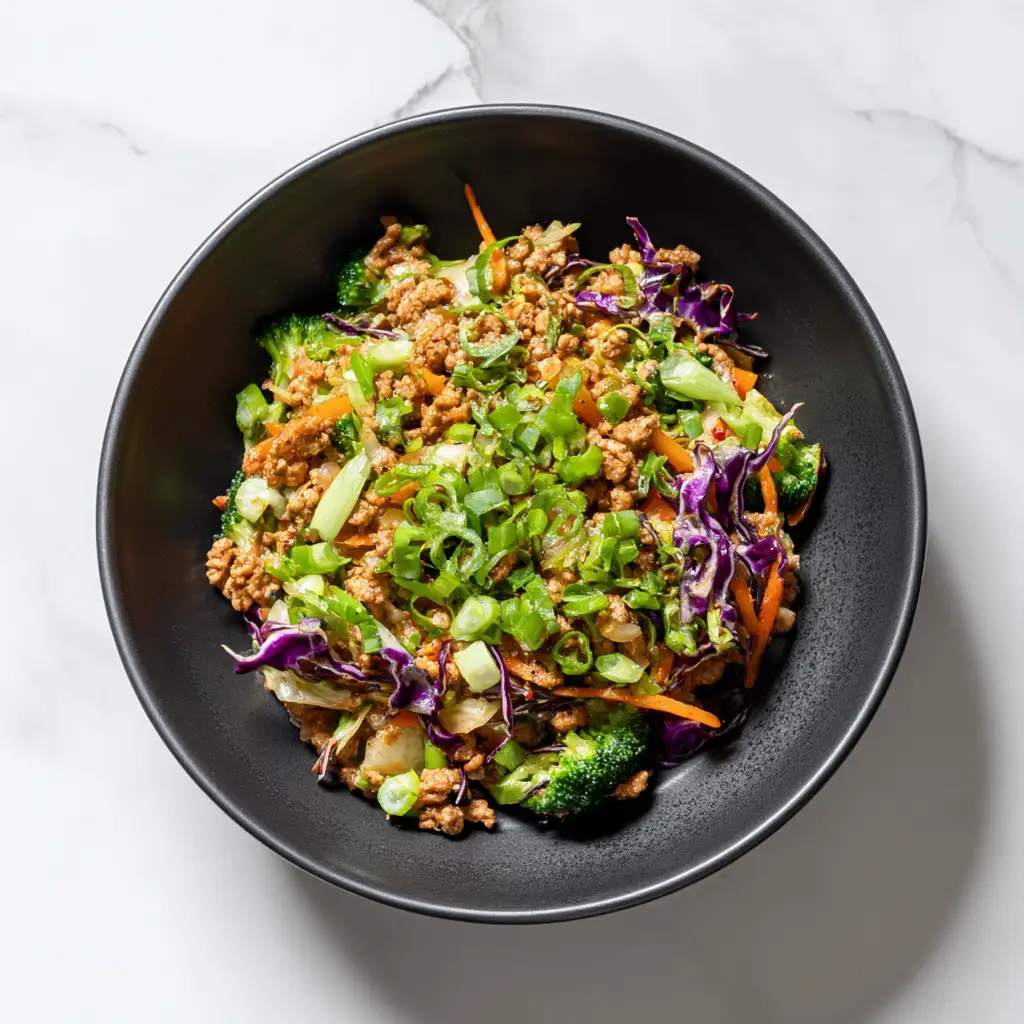 A close-up shot of the egg roll in a bowl ingredients cooking in a pan. This illustrates the easy cooking process for this low carb recipe.