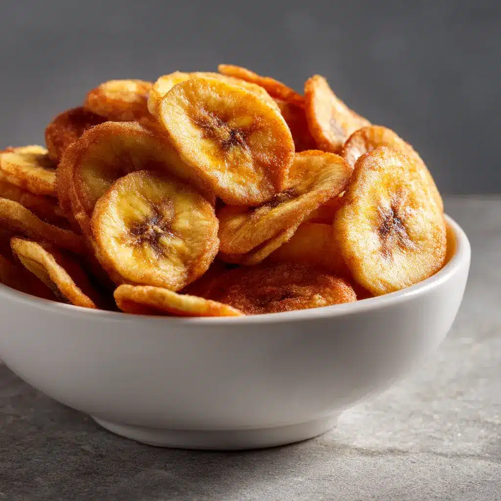 A batch of freshly cooked, golden-brown banana chips spread out on a cooling rack after coming out of the air fryer. They look incredibly crispy and delicious.