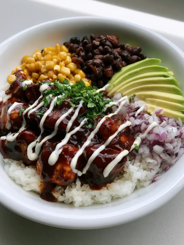 BBQ Chicken Rice Bowl: The Ultimate Easy Weeknight Dinner 1 Close up of seared chicken cubes heavily coated in thick dark BBQ sauce in a white bowl.
