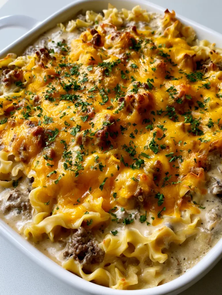 A top-down view of the Amish Hamburger Casserole highlighting the melted sharp cheddar cheese blanket and crispy edges.
