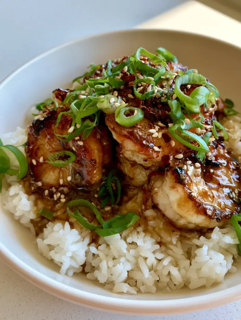 A top-down smartphone photo of a Honey Garlic Shrimp Rice Bowl featuring charred shrimp and an amber glaze.