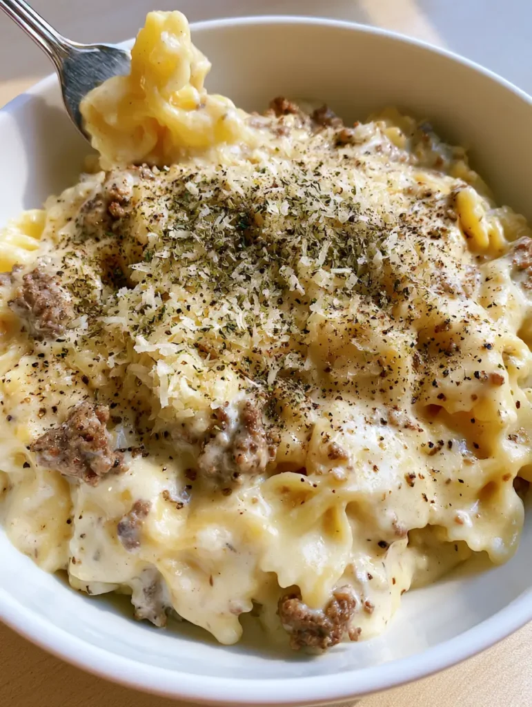 Shredded parmesan cheese and dried herbs garnished over Creamy Parmesan Garlic Beef Bowtie Pasta.